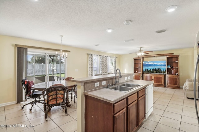 kitchen featuring sink, light tile patterned floors, a center island with sink, dishwasher, and hanging light fixtures