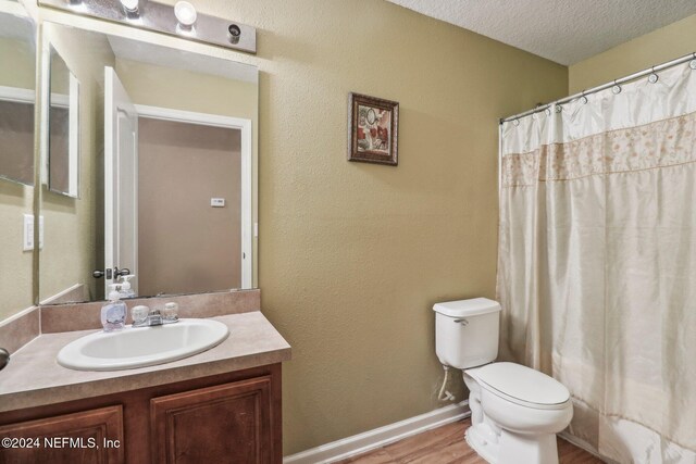 bathroom featuring vanity, a shower with curtain, toilet, a textured ceiling, and wood-type flooring