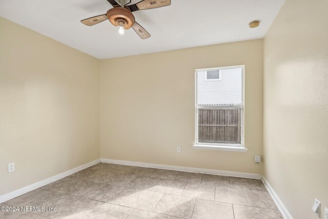 tiled empty room with ceiling fan