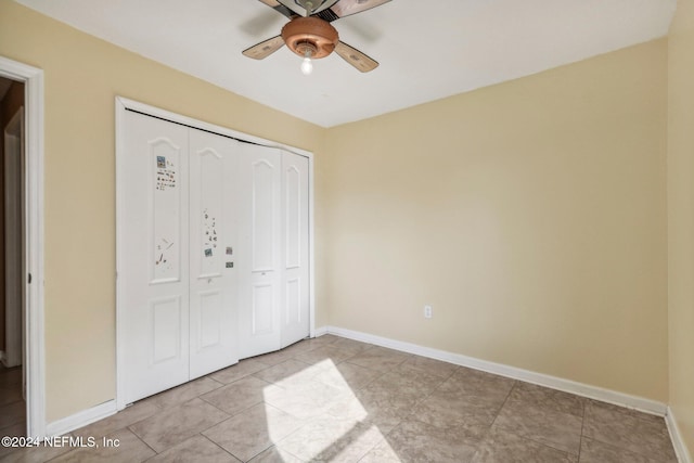 unfurnished bedroom featuring light tile patterned floors, a closet, and ceiling fan