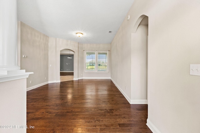 unfurnished living room with dark wood-type flooring