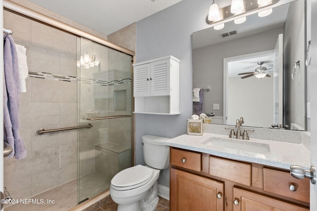 bathroom featuring vanity, a shower with door, toilet, and ceiling fan