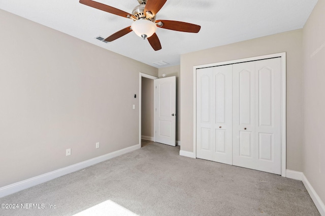 unfurnished bedroom with light carpet, a closet, and ceiling fan