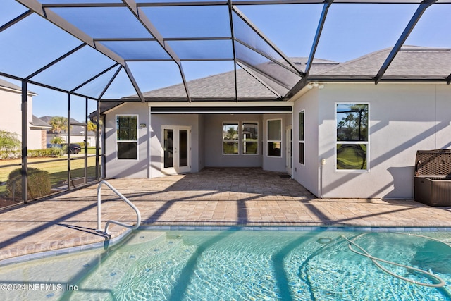 rear view of house featuring a lanai, a patio, and french doors