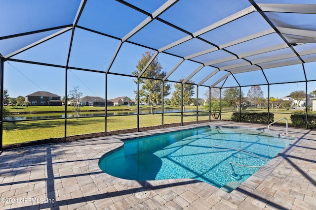 view of pool with a lawn, glass enclosure, a water view, and a patio