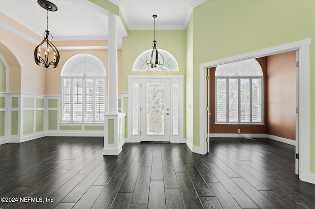 entryway with dark hardwood / wood-style flooring, ornate columns, crown molding, and plenty of natural light