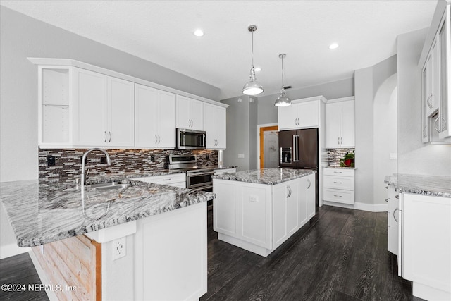 kitchen featuring sink, a kitchen island, light stone countertops, white cabinetry, and appliances with stainless steel finishes