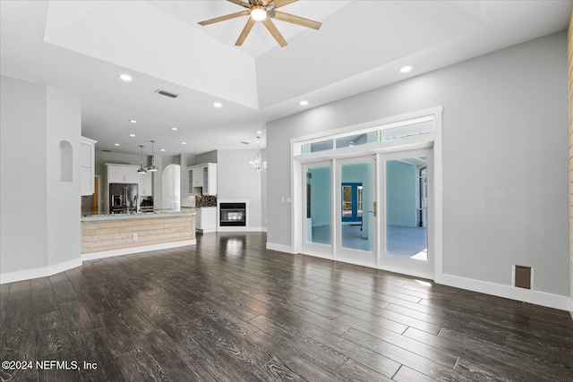 unfurnished living room featuring dark wood-type flooring and ceiling fan