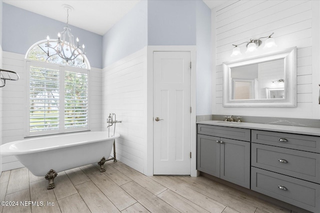 bathroom featuring a bathing tub, hardwood / wood-style floors, plenty of natural light, and a notable chandelier