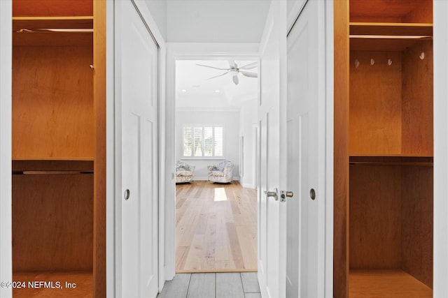 hall with light wood-type flooring and crown molding