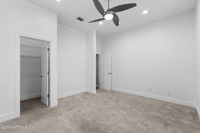 unfurnished bedroom featuring ceiling fan, a closet, and light colored carpet