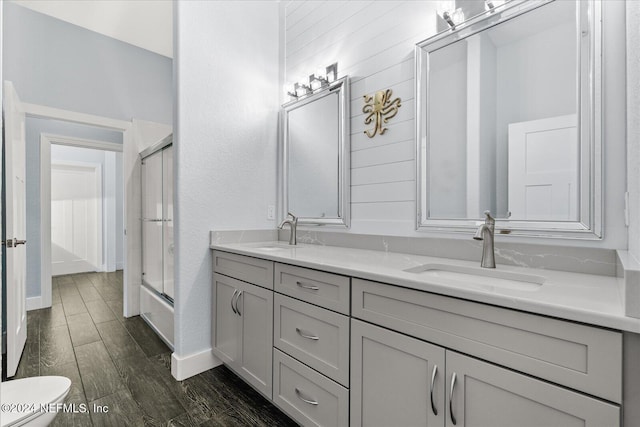 full bathroom featuring toilet, combined bath / shower with glass door, vanity, and hardwood / wood-style flooring