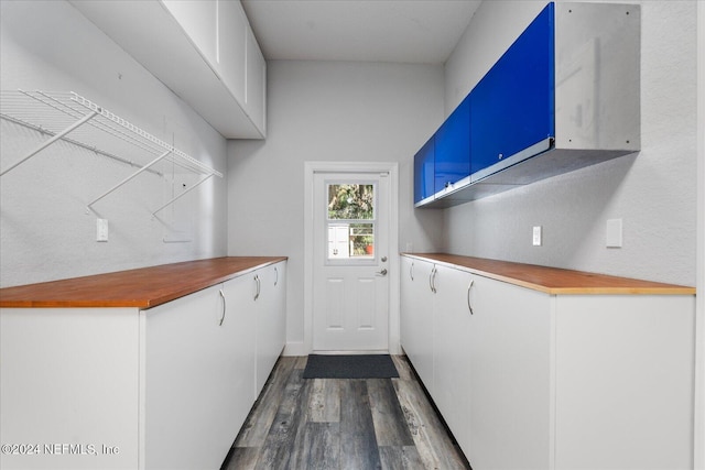 kitchen featuring white cabinetry, blue cabinetry, and dark hardwood / wood-style floors