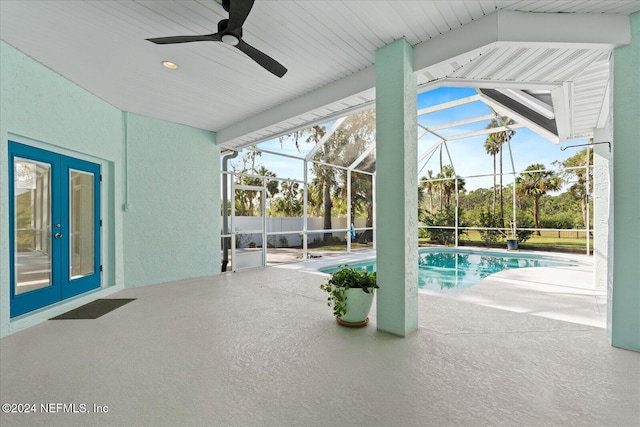 view of pool featuring french doors, glass enclosure, a patio, and ceiling fan