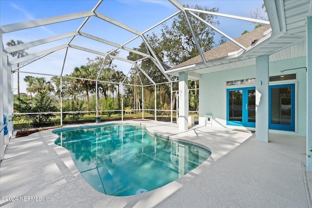 view of swimming pool featuring a patio area, french doors, and a lanai