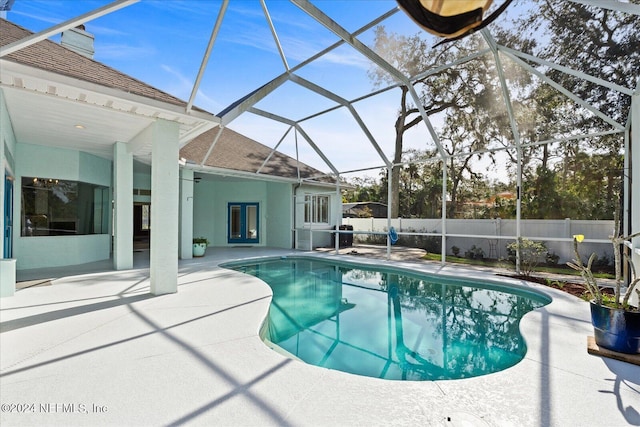 view of pool with ceiling fan, glass enclosure, a patio, and french doors