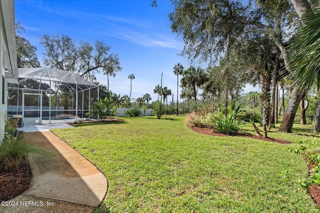 view of yard featuring glass enclosure and a pool