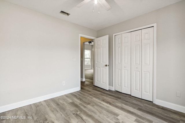 unfurnished bedroom with a closet, light hardwood / wood-style floors, and ceiling fan