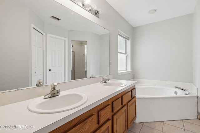 bathroom featuring plus walk in shower, vanity, and tile patterned floors