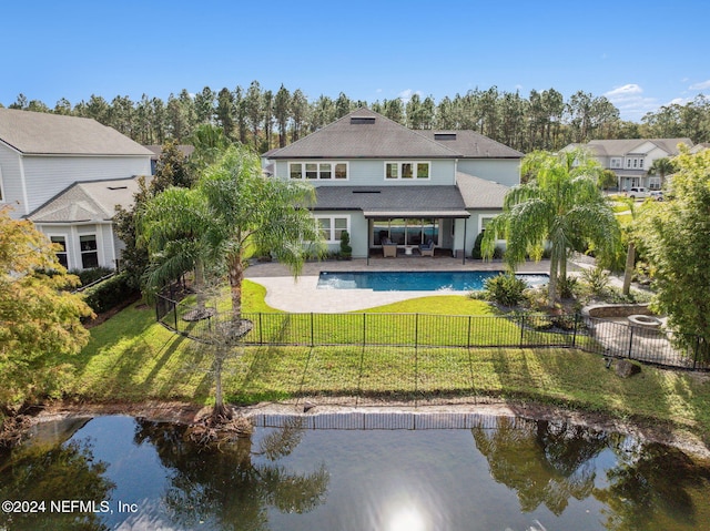 rear view of property featuring an outdoor hangout area, a fenced in pool, a patio area, and a lawn