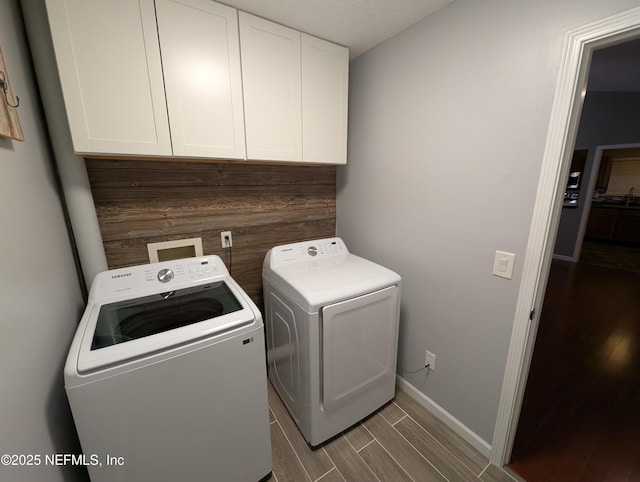 laundry room featuring cabinets and washer and clothes dryer