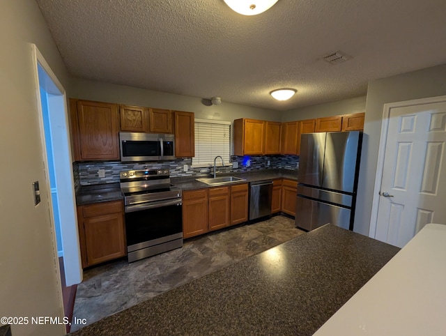 kitchen featuring sink, backsplash, stainless steel appliances, and a textured ceiling