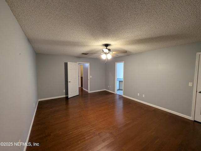 spare room featuring dark wood-type flooring, a textured ceiling, and ceiling fan