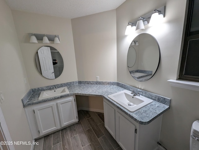 bathroom featuring vanity, toilet, and a textured ceiling