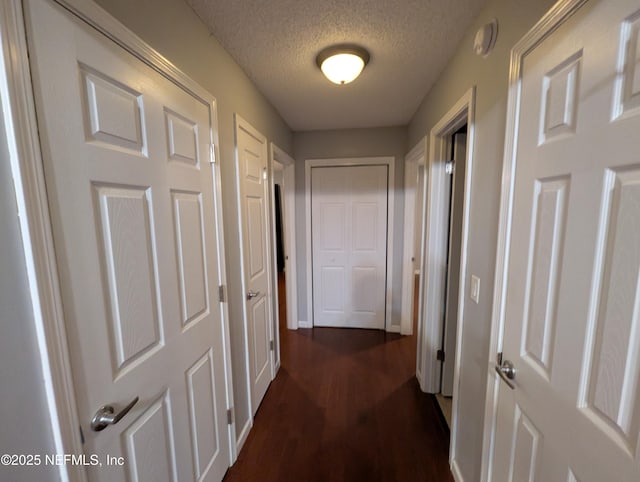 corridor featuring dark hardwood / wood-style flooring and a textured ceiling