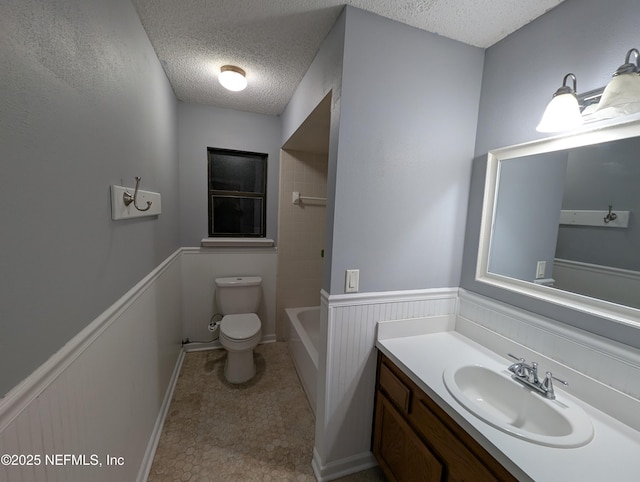 bathroom featuring vanity, toilet, and a textured ceiling