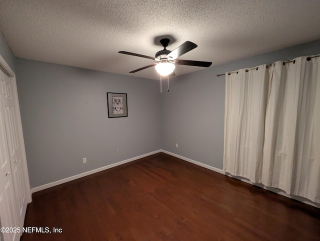 unfurnished bedroom featuring a closet, dark hardwood / wood-style floors, a textured ceiling, and ceiling fan