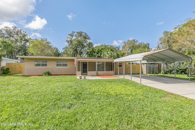 ranch-style house featuring a sunroom, a carport, and a front yard