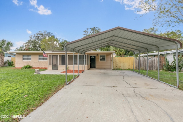 view of front facade with a front yard, a sunroom, and a carport