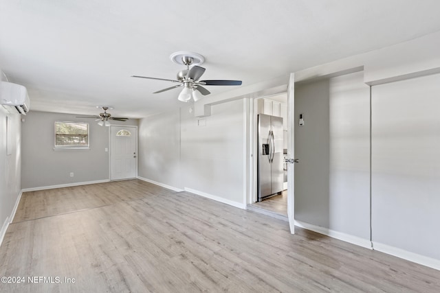 unfurnished room featuring light wood-type flooring, ceiling fan, and a wall mounted AC