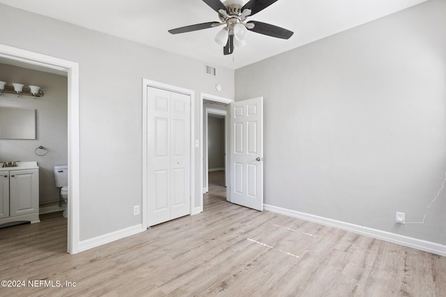 unfurnished bedroom with ceiling fan, connected bathroom, a closet, and light hardwood / wood-style flooring