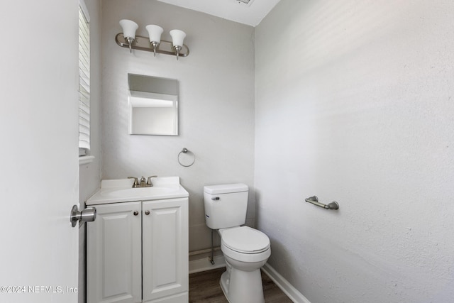 bathroom featuring toilet, vanity, and hardwood / wood-style flooring