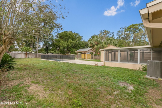 view of yard featuring a gazebo, a sunroom, central AC, a patio area, and a swimming pool