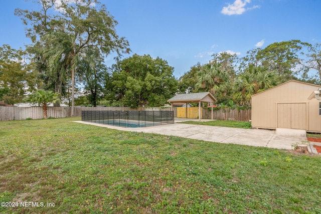 view of yard with a storage shed, a patio area, a fenced in pool, and a gazebo