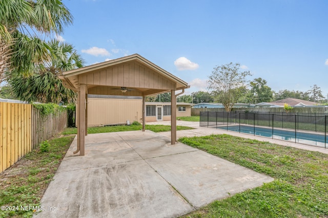 view of patio with ceiling fan and a fenced in pool