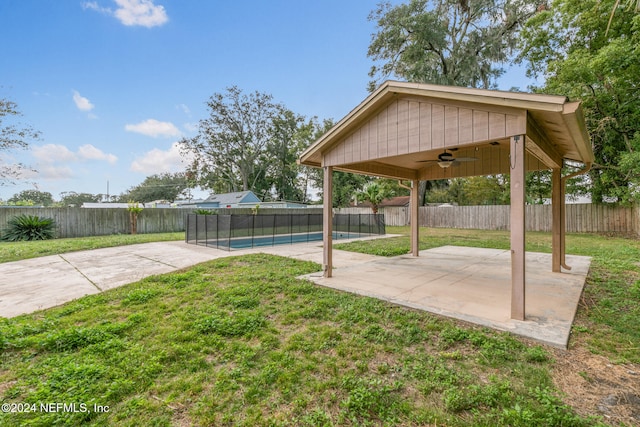 view of yard featuring ceiling fan, a patio, and a fenced in pool