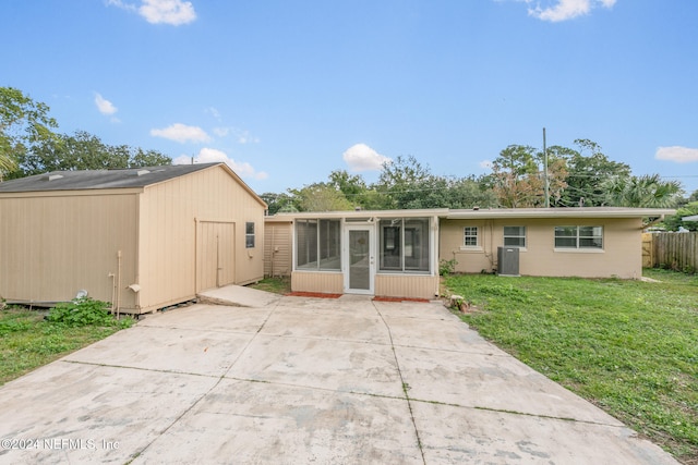 back of property with a sunroom, a yard, and cooling unit