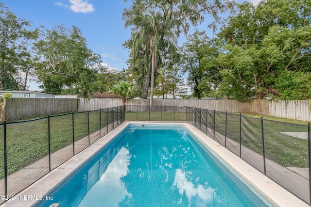 view of pool featuring a lawn