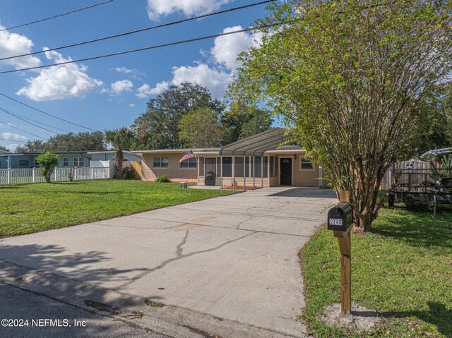 view of front of home with a front lawn and a sunroom