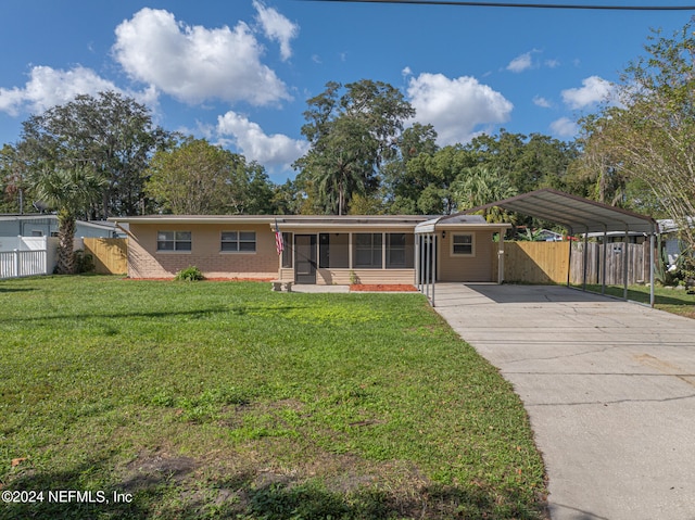 single story home featuring a front yard, a sunroom, and a carport