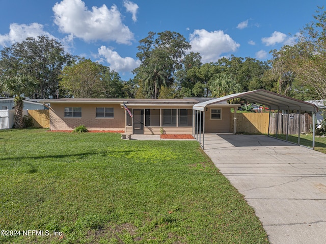 ranch-style home with a front yard, a sunroom, and a carport