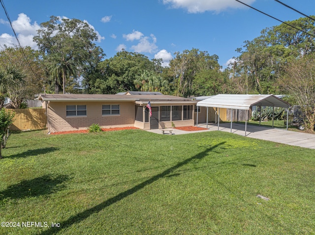 single story home with a front lawn, a sunroom, and a carport