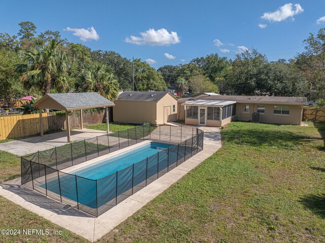 view of pool featuring a shed, a lawn, a sunroom, and a gazebo