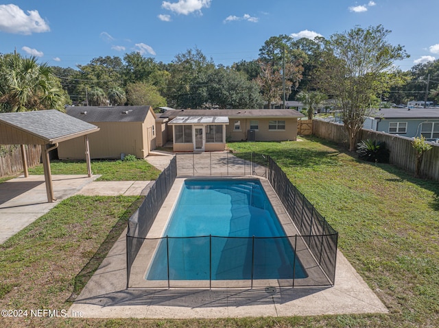 view of pool with a sunroom, an outbuilding, and a yard