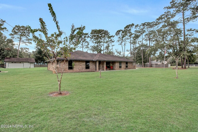 view of front facade featuring a front yard and an outbuilding