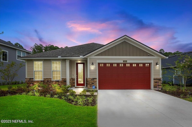 craftsman-style home featuring a garage and a yard